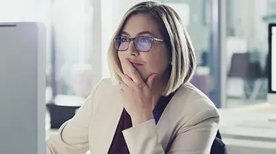 IVANS eDocs and Messages Download: What Your Agencies Want From Your Business A businesswoman wearing glasses, working on a desktop computer