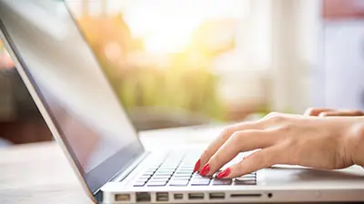 5 Steps to Maximizing Your Insurer Relationships with IVANS A woman's hands typing on a laptop keyboard